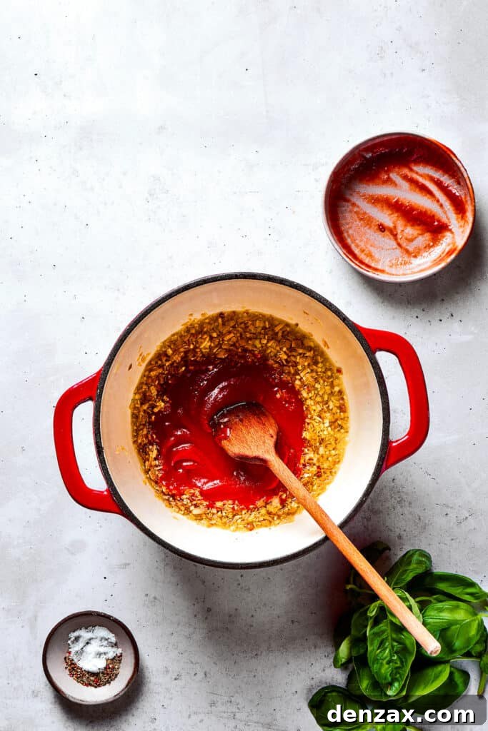 Sauteing tomato paste with aromatics.