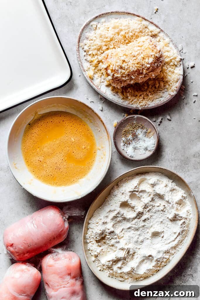 Coating stuffed chicken in breadcrumbs.