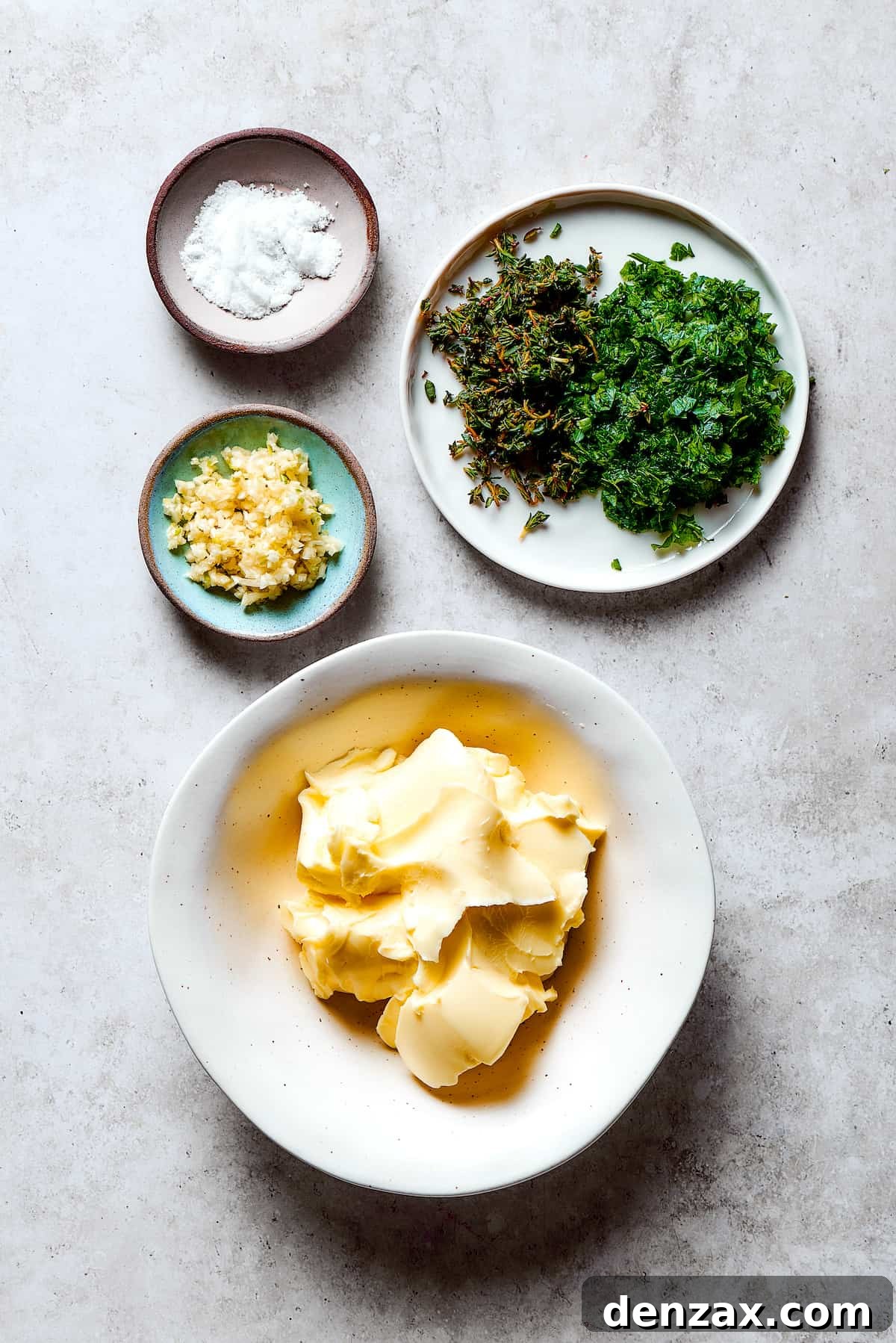 Ingredients for garlic herb butter measured and arranged on a work surface.
