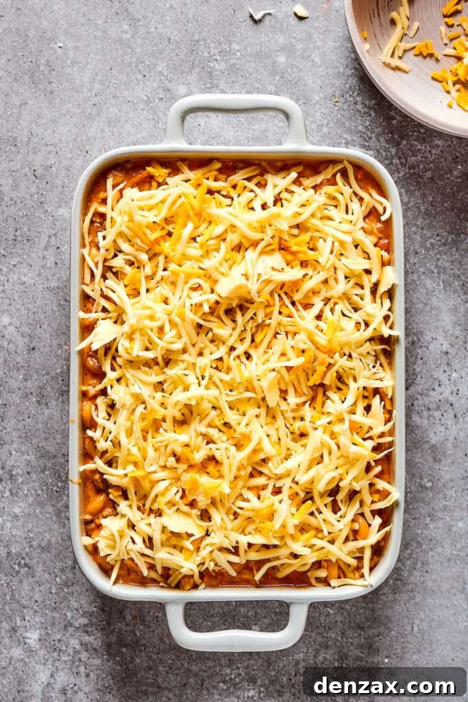 Overhead shot of a casserole dish covered in shredded cheese.