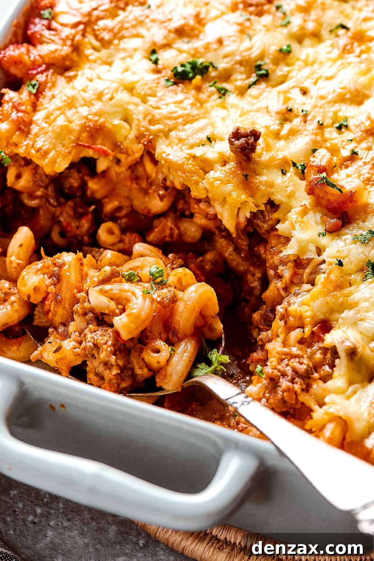 A casserole with a portion scooped out, and a serving spoon resting in the dish.
