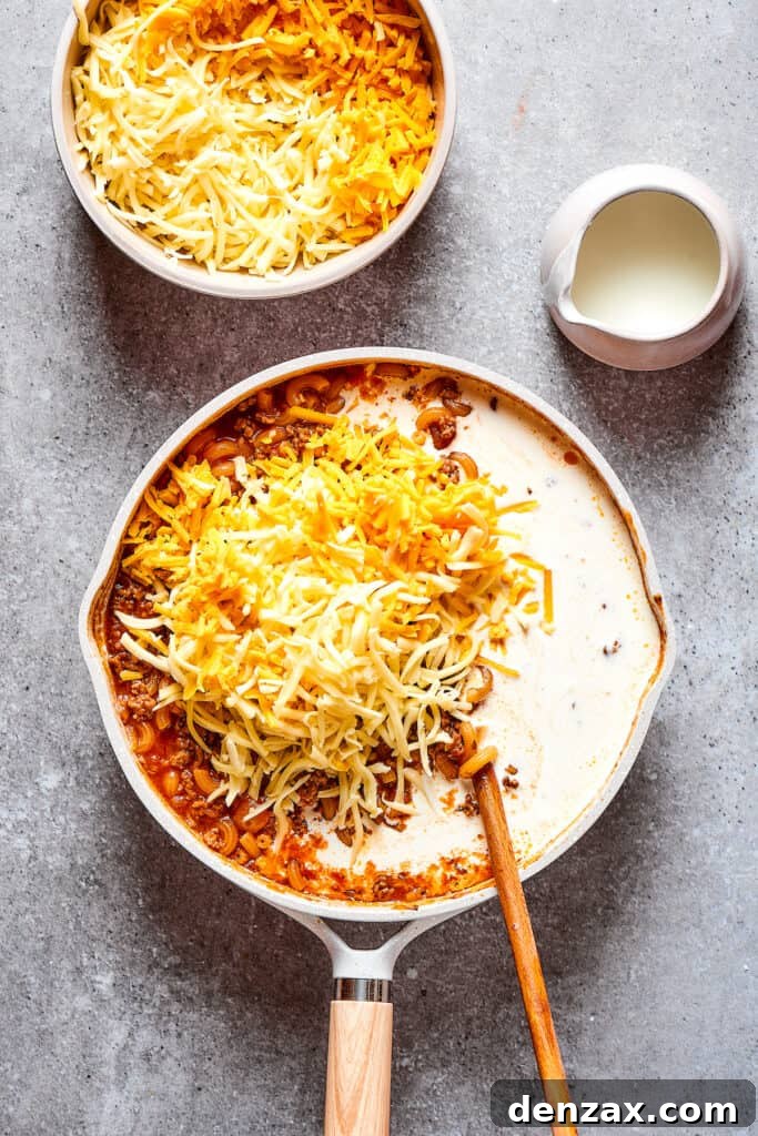 Stirring cream and cheese into a skillet dish.