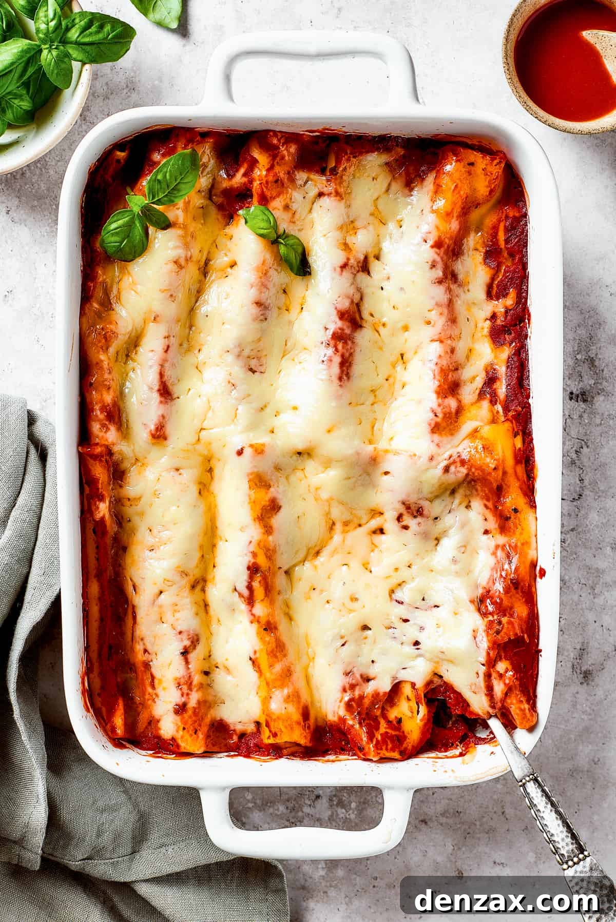 Baked pasta in a dish garnished with fresh basil.