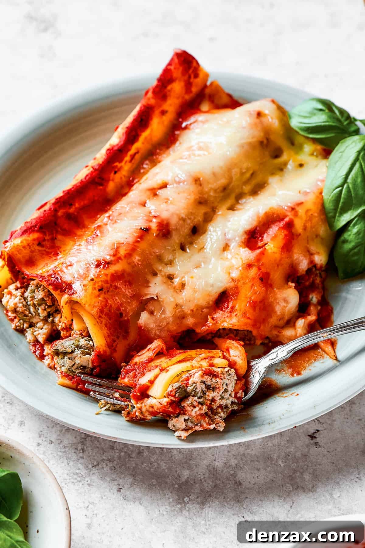 Piercing baked manicotti with a fork.