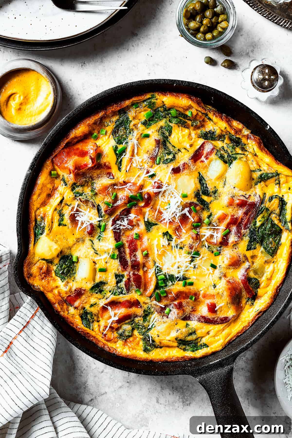 overhead shot of a fully-cooked frittata in a cast-iron skillet.