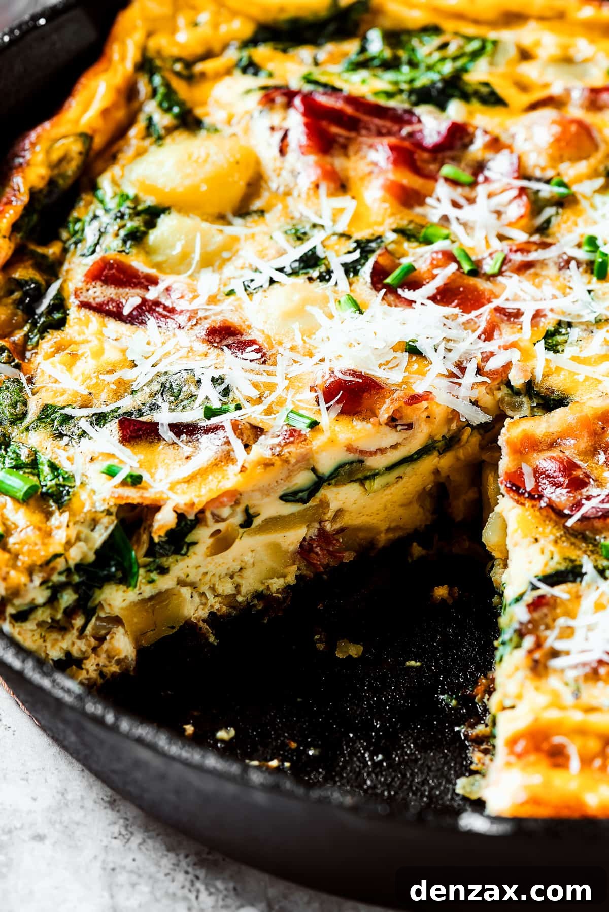 A baked frittata with a slice removed.