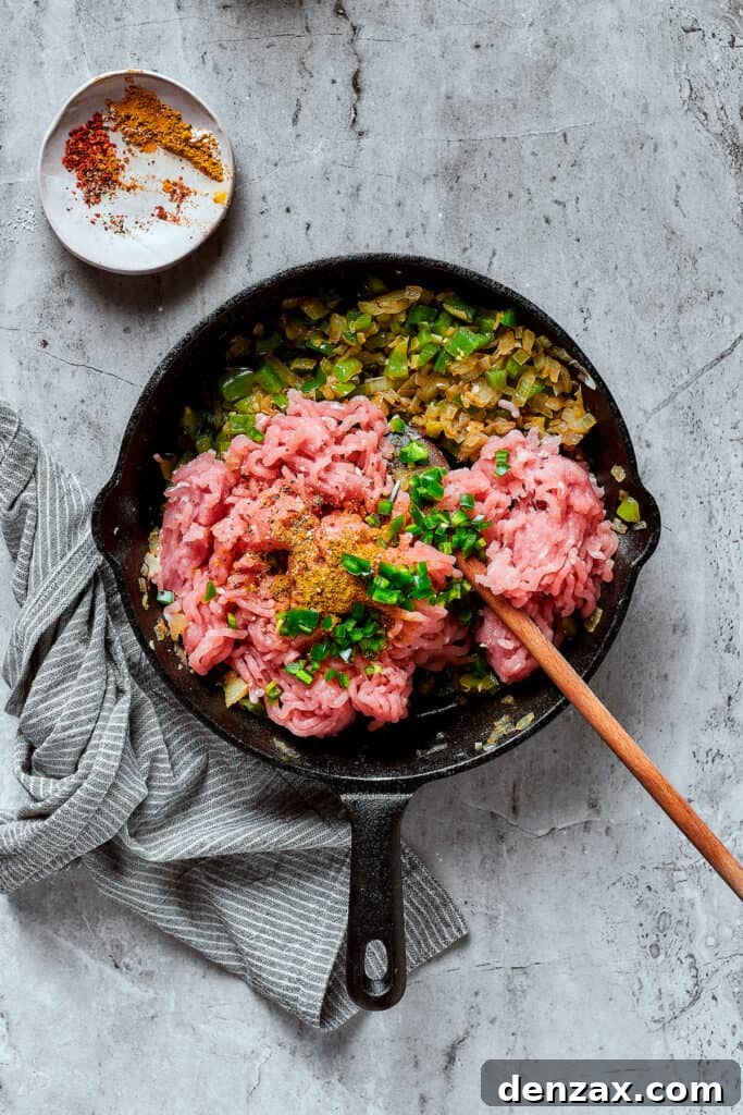 Ground turkey and other ingredients cooking in a skillet.