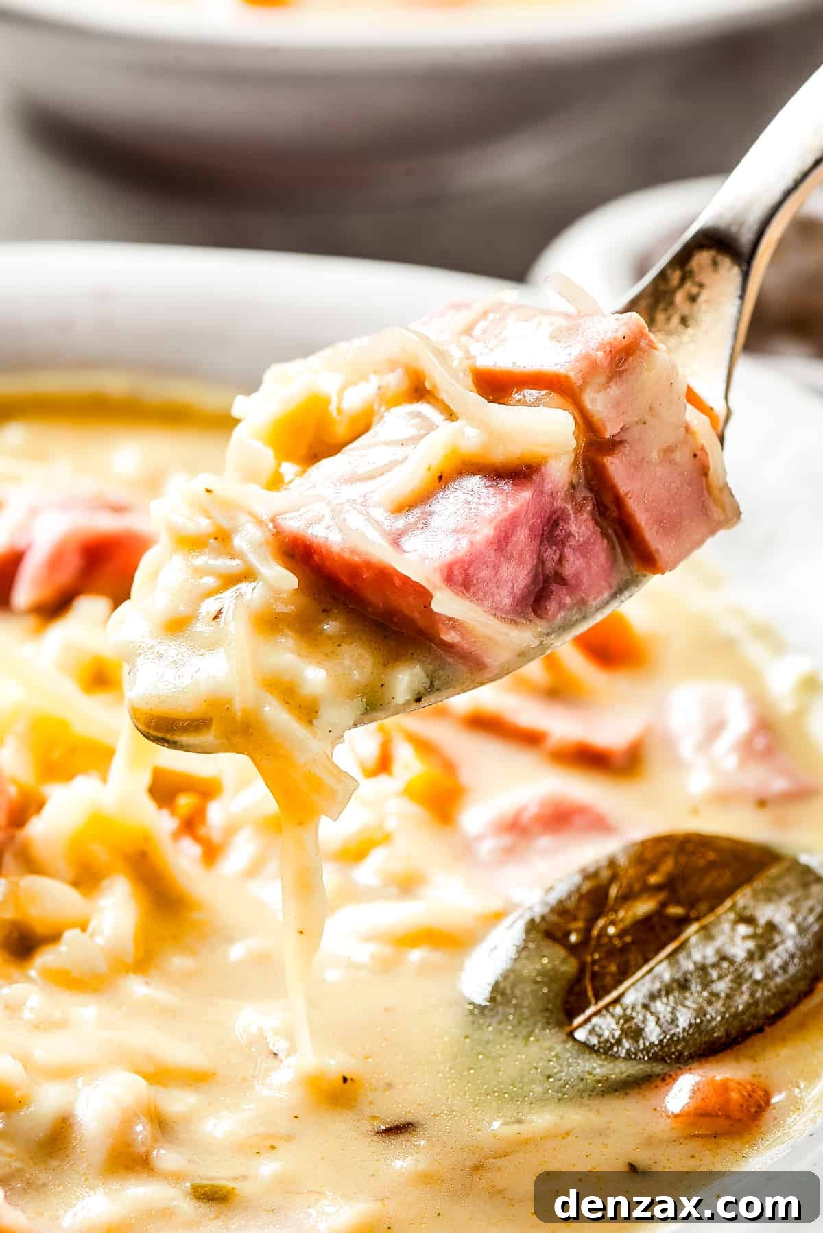 Lifting reuben soup out of a bowl with a spoon.