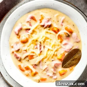 A bowl of creamy soup with a bay leaf in it.