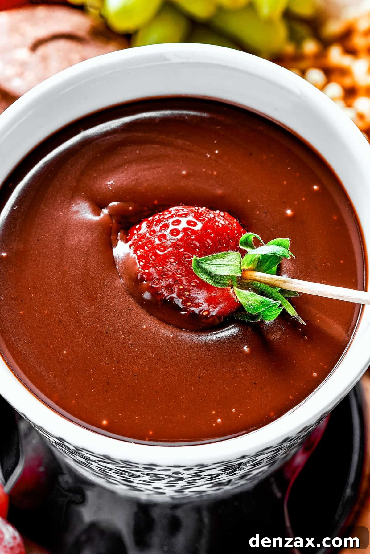 Dipping a strawberry in chocolate fondue.
