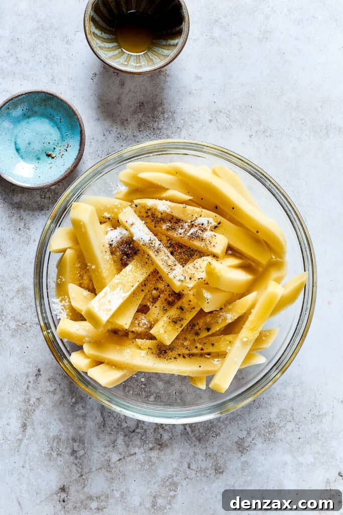 Seasoning the uncooked fries.