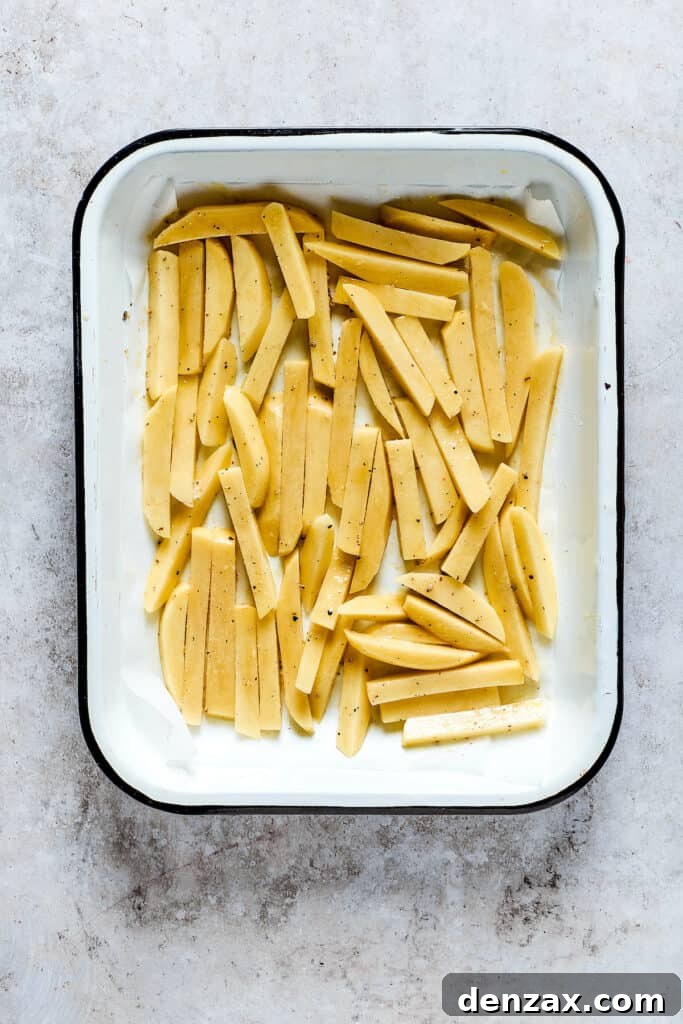Unbaked fries in a baking dish.