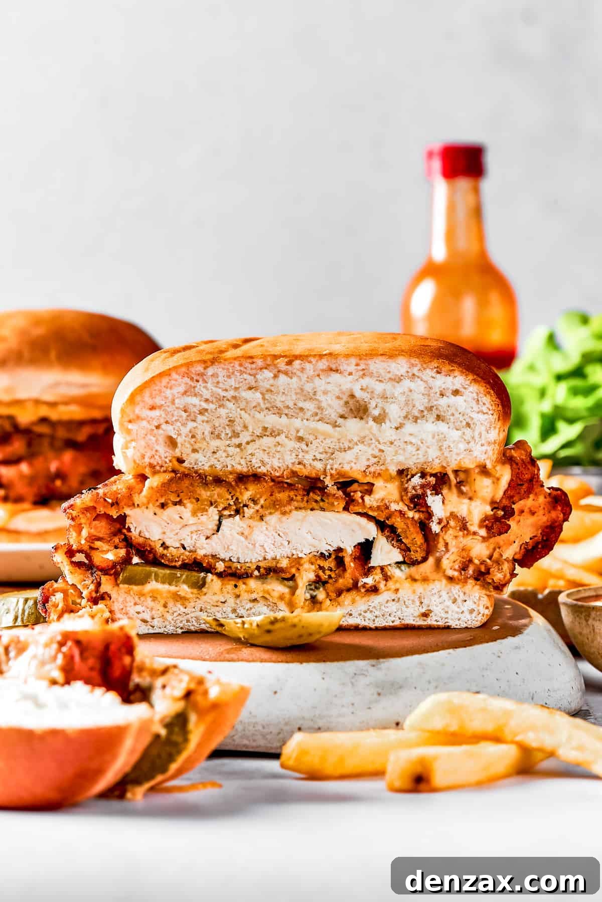 A homemade chicken sandwich cut in half to show the texture of the fried chicken and bun.