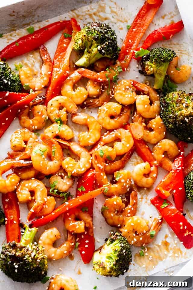 Overhead photo of a baking sheet with cooked shrimp, broccoli, and red bell peppers.