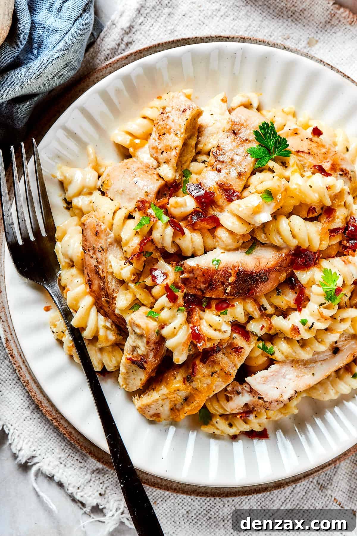 This bold and creamy Chicken Bacon Ranch Pasta recipe is a savory, smoky dinner dish that's bursting with flavor! The best comfort food! A dinner plate of pasta and chicken with creamy sauce and bacon.