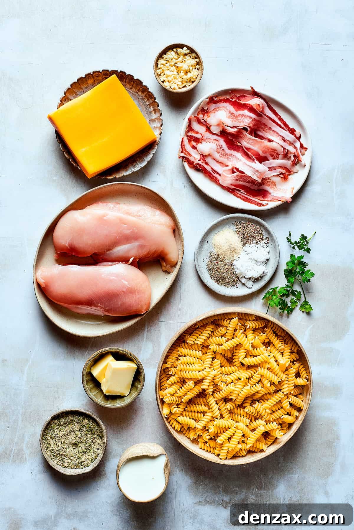 This bold and creamy Chicken Bacon Ranch Pasta recipe is a savory, smoky dinner dish that's bursting with flavor! The best comfort food! Ingredients for chicken bacon ranch pasta measured and arranged on a work surface.