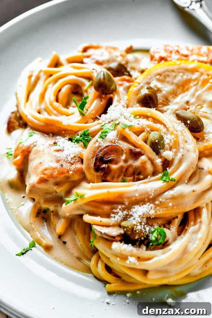 Close-up shot of creamy pasta with capers, lemon, and chicken.