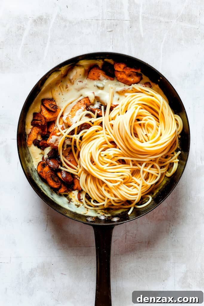 Adding mushrooms, chicken, and pasta to a skillet.