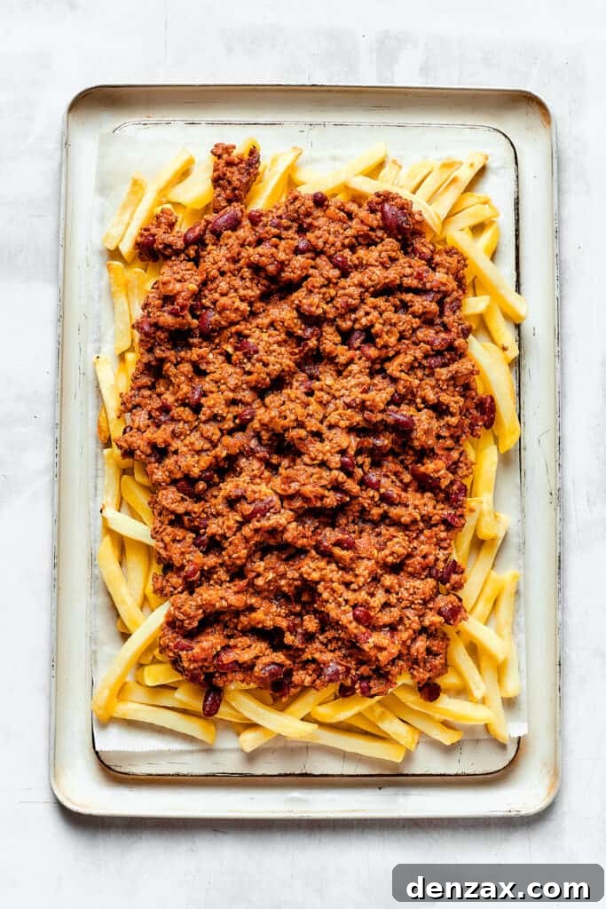 A baking sheet with french fries covered in chili.