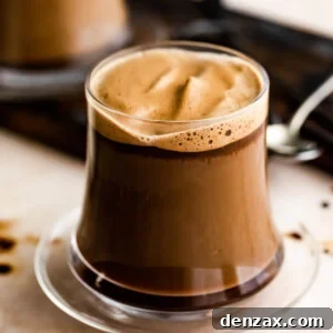 A glass mug with Caffe Macchiato and another mug set right behind it.