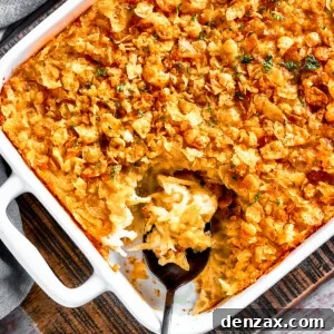 A casserole dish with hashbrown casserole. Some of it has been spooned out, and a serving spoon is set inside the casserole dish.