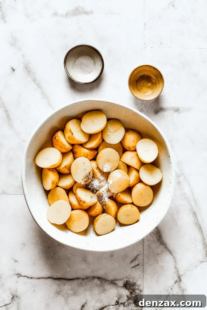 These tender potatoes with a crunchy, cheesy crust are the easiest, tastiest side dish you'll ever make. A viral TikTok recipe you'll love! Cut potatoes in a bowl with salt, pepper, and oil.