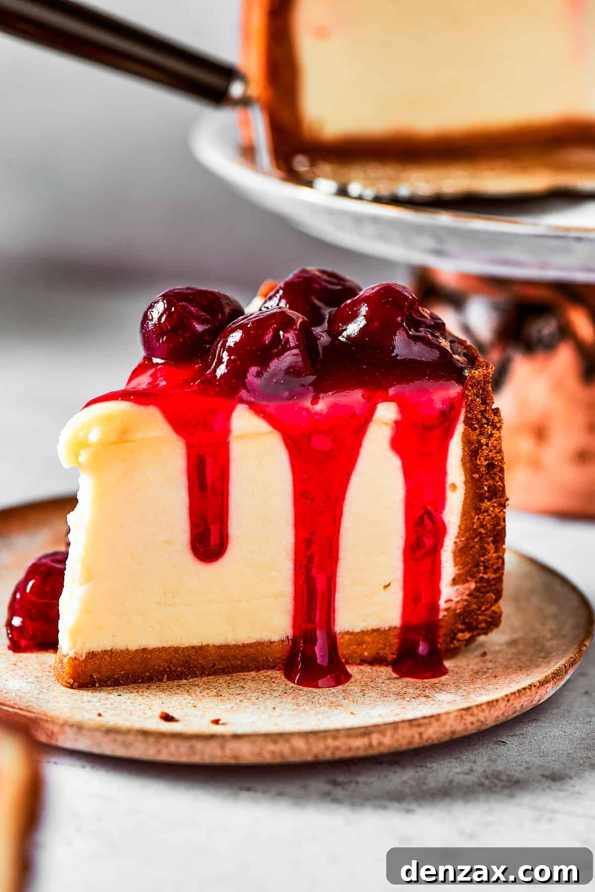 A slice of cherry cheesecake served on a small dessert plate.