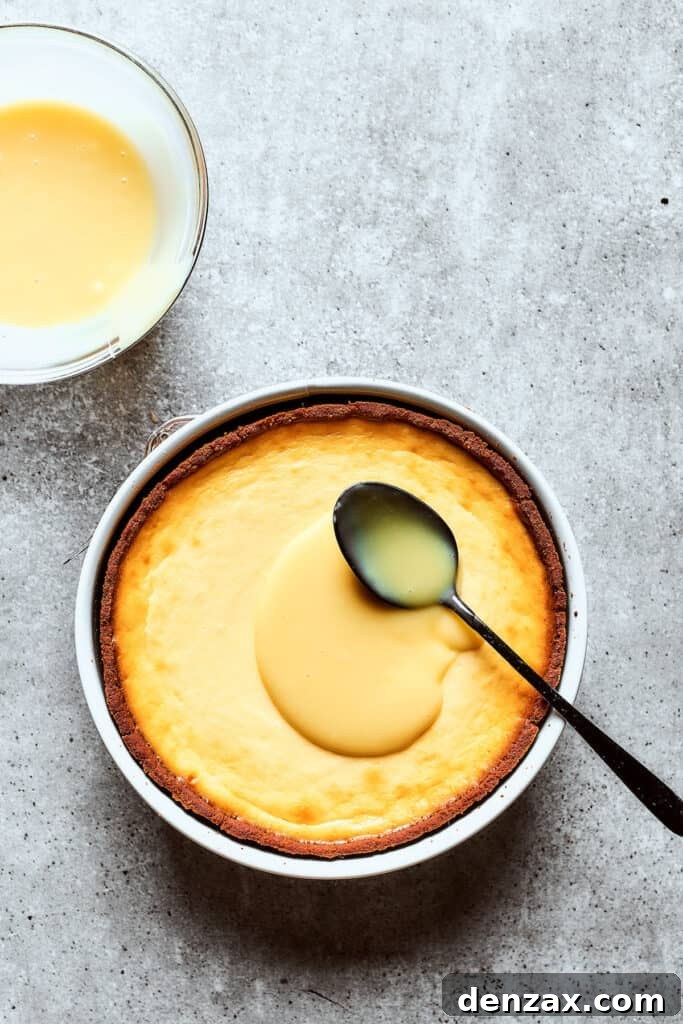 Spreading white chocolate ganache over cheesecake.