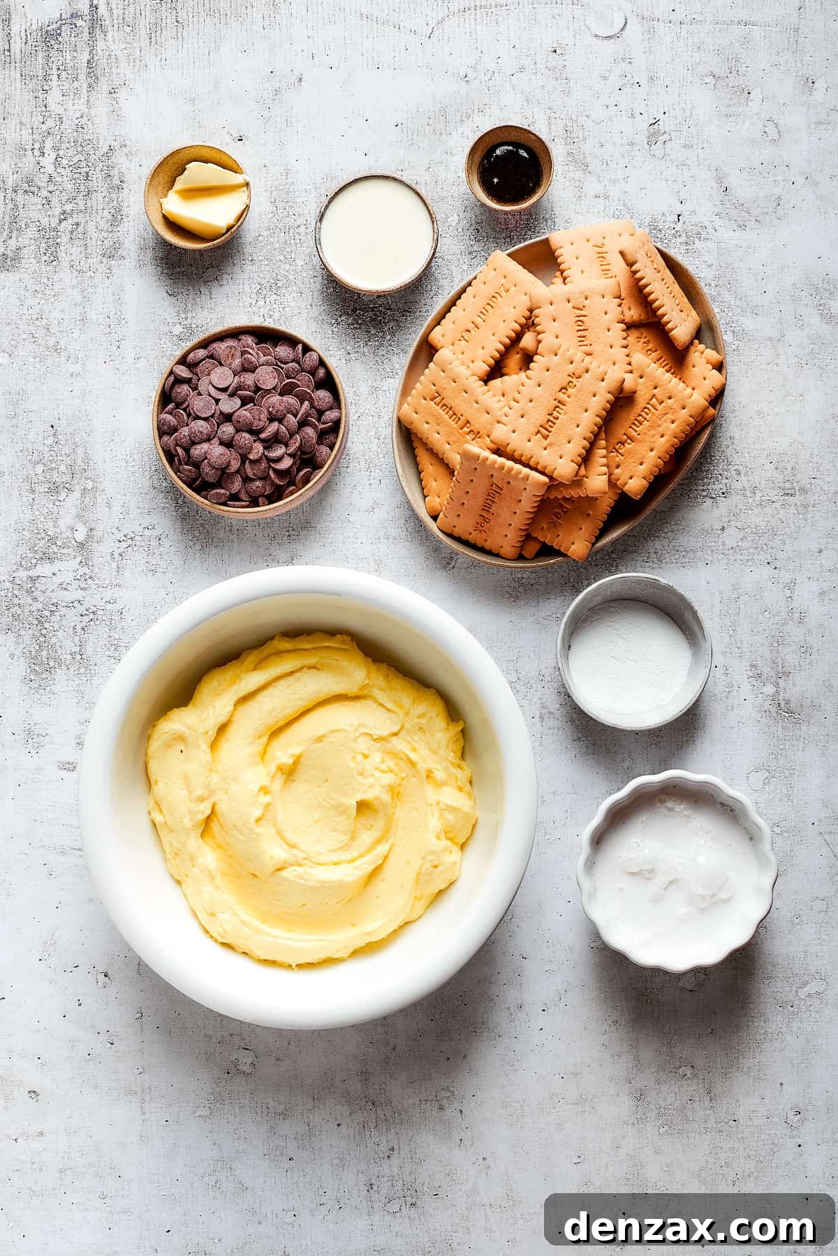 Chocolate eclair cake is loaded with creamy and smooth pudding, decadent chocolate ganache, and tender cookies, and it's so easy to make. Overhead view of the ingredients needed for chocolate eclair cake: pudding, cookies, chocolate chips, cream, milk, butter, vanilla, and powdered sugar.