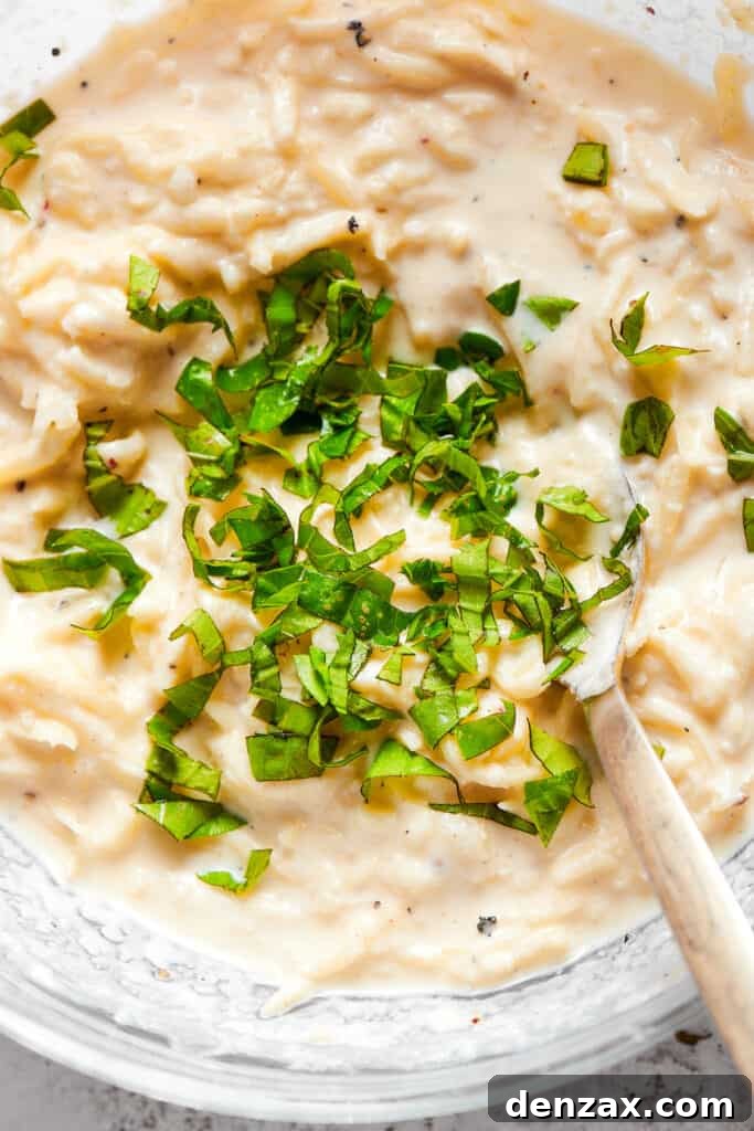 Close up overhead view of basil being mixed into a cheese filling.