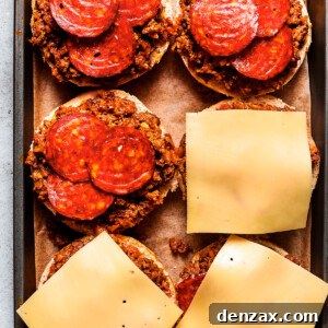 Ultimate Pizza Burger Recipe: How to Make a Cheesy Pizza-Style Burger 3 Cheese slices are placed on top of pizza burgers on a tray.