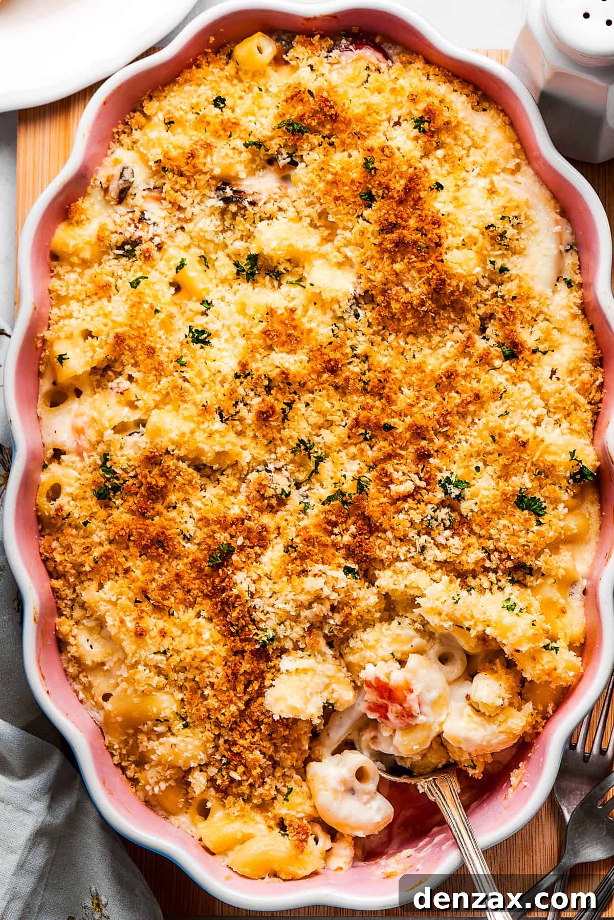 This rich seafood mac and cheese recipe folds flavorful crab or shrimp into a creamy sauce and tosses it with tender pasta. Truly special. Cooked Seafood mac and cheese with a serving spoon ready to take some out.
