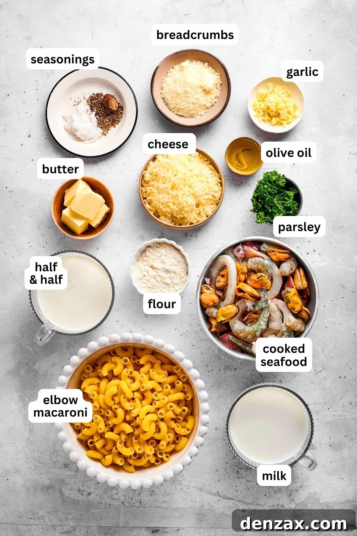 This rich seafood mac and cheese recipe folds flavorful crab or shrimp into a creamy sauce and tosses it with tender pasta. Truly special. Overhead view of all the ingredients used for seafood mac and cheese.