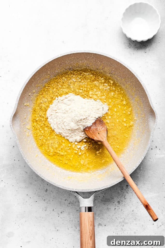 Making the roux for the sauce Adding flour to hot garlic butter in a saute pan.