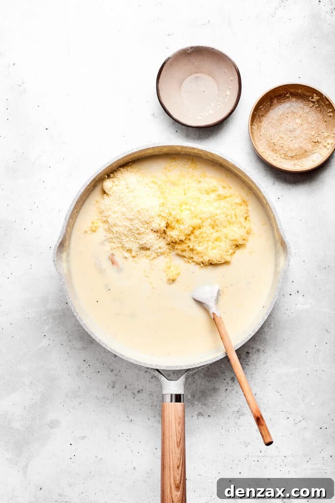 Stirring in cheese until smooth Adding cheese to the sauce base.