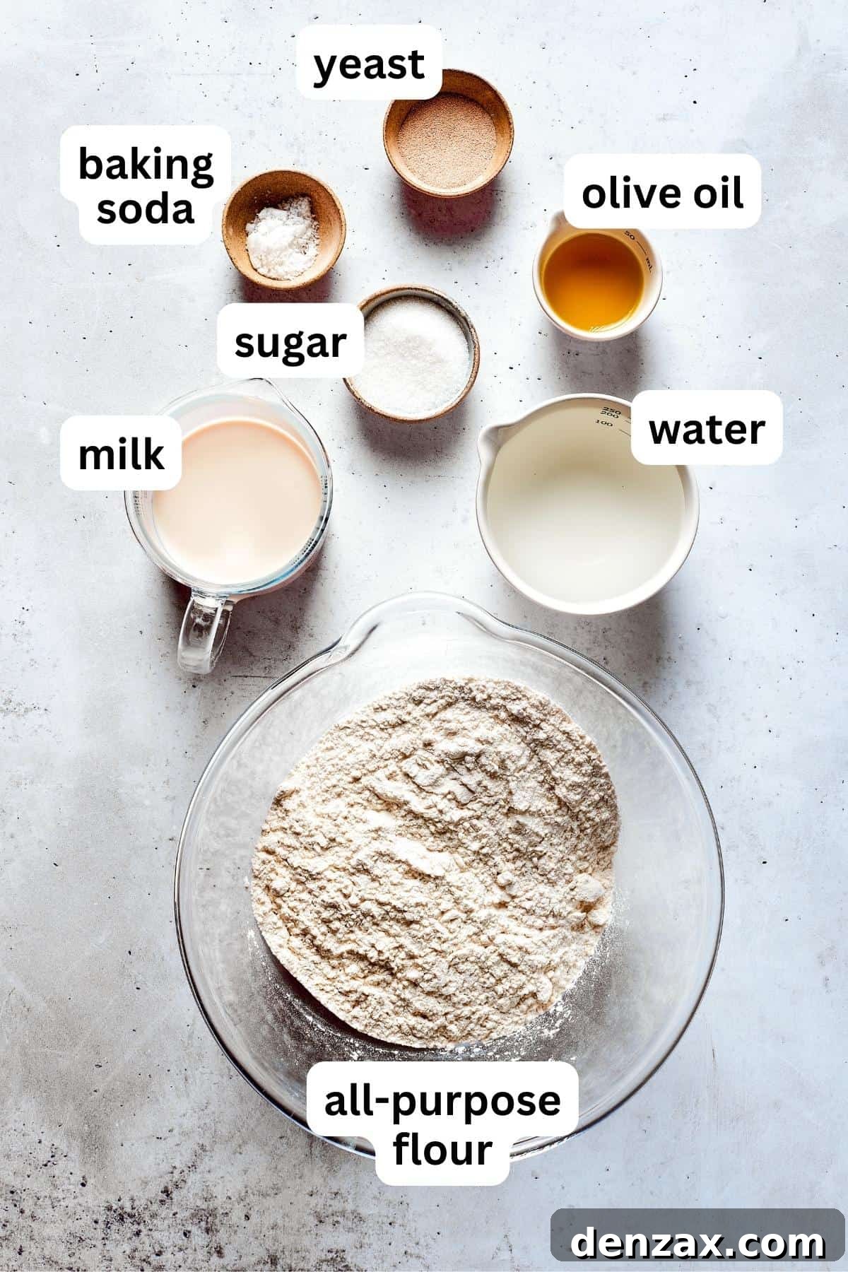 Ingredients for soft pretzels are shown portioned out into bowls: flour, yeast, sugar, milk, butter, and water.