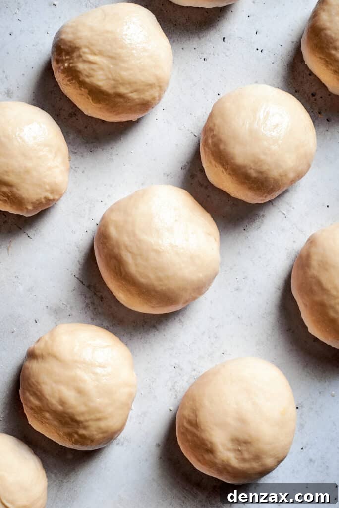 Balls of soft pretzel dough on a white background.