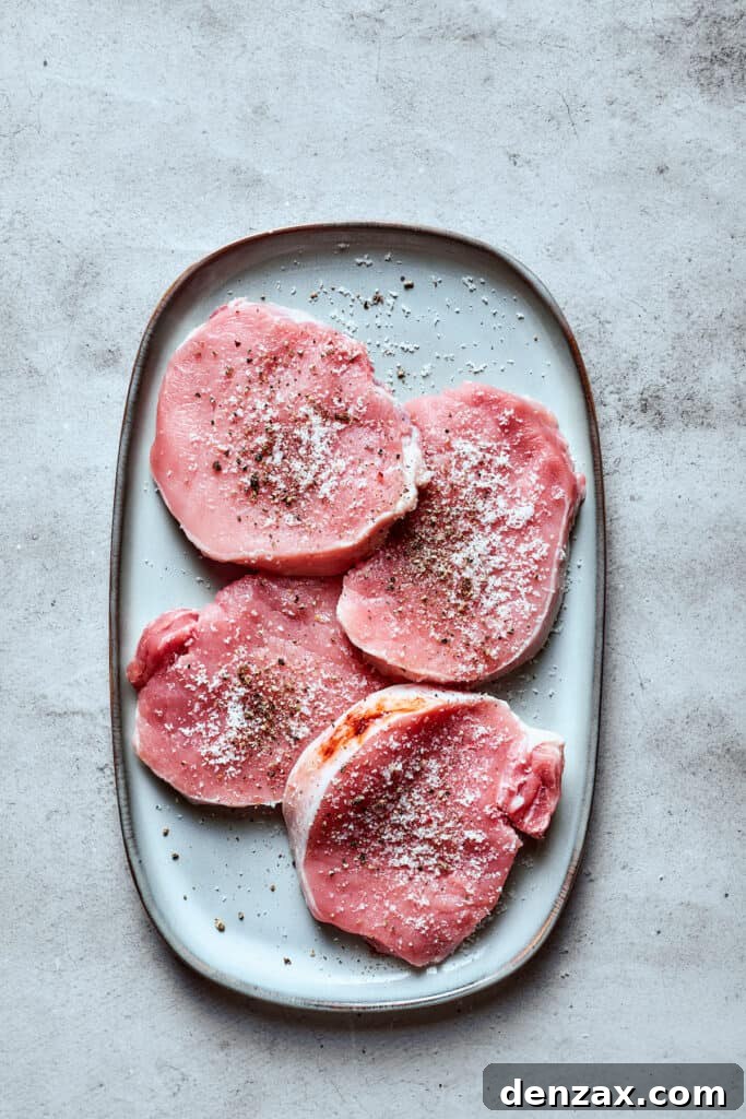 These Honey Garlic Pork Chops are the perfect blend of sweet-salty with a punch of extra flavor from minced garlic. Ready in 20 minutes! Pork chops seasoned with salt and pepper on a white tray.