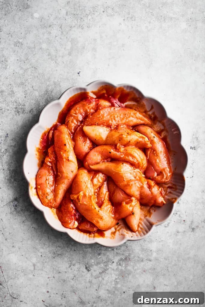 Chicken tenders turn red after being seasoned with hot sauce.