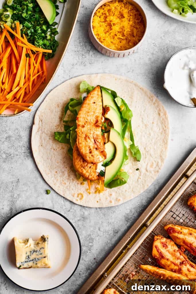 A seasoned chicken tender is placed on vegetables and a tortilla.