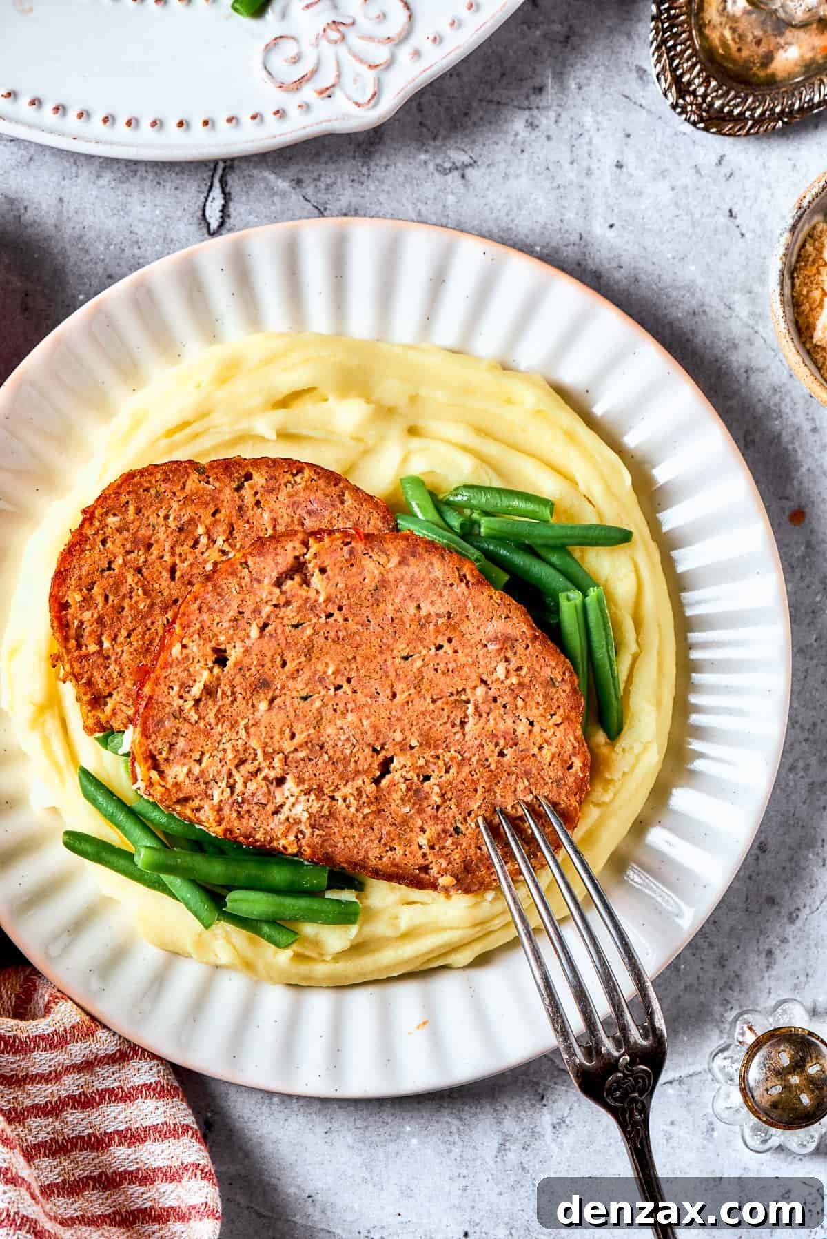 Two slices of brown sugar meatloaf served over mashed potatoes.