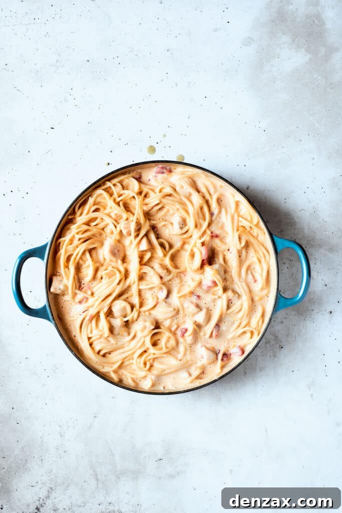 Chicken and spaghetti fully incorporated into the creamy sauce.