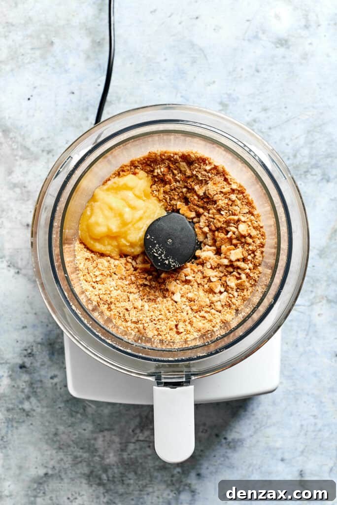 Crush crackers and combine with melted butter. Ritz crackers and butter are placed in a food processor.