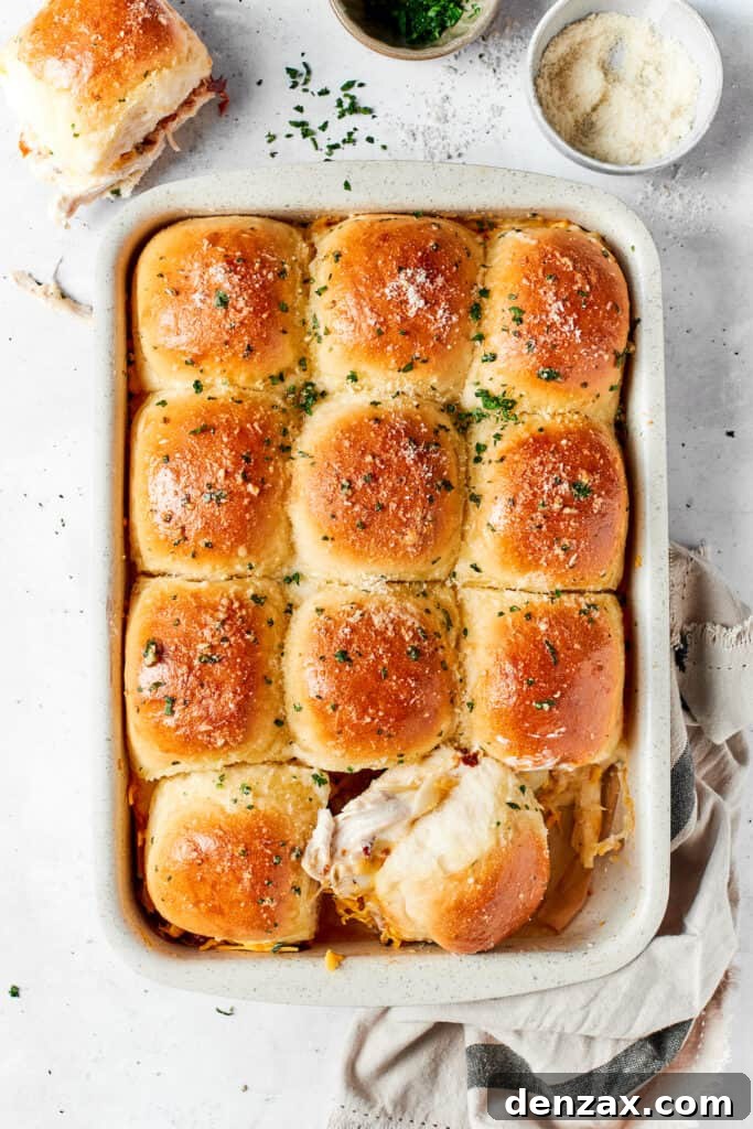 Chicken Bacon Ranch Sliders feature tender bites of shredded chicken, crisp bacon Ranch dressing, melted cheese, and sweet rolls. A pan of chicken bacon ranch sliders on a table.