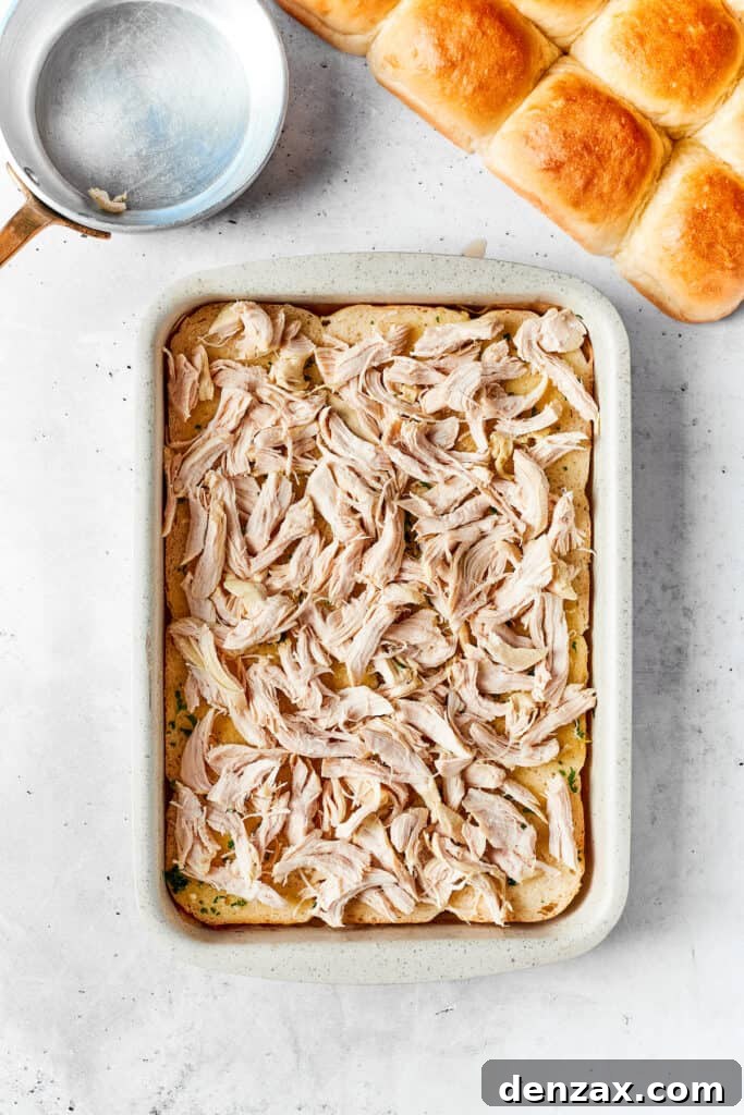 Chicken Bacon Ranch Sliders feature tender bites of shredded chicken, crisp bacon Ranch dressing, melted cheese, and sweet rolls. Shredded chicken is added to the sliders.