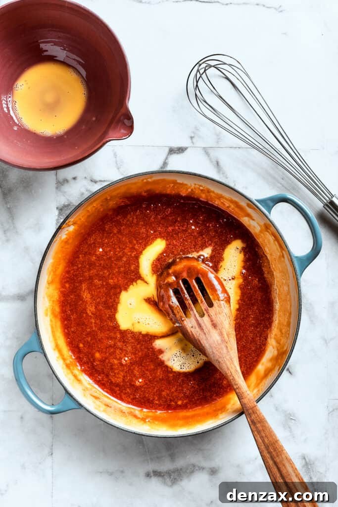 A wooden spoon mixed the eggs into the filling.