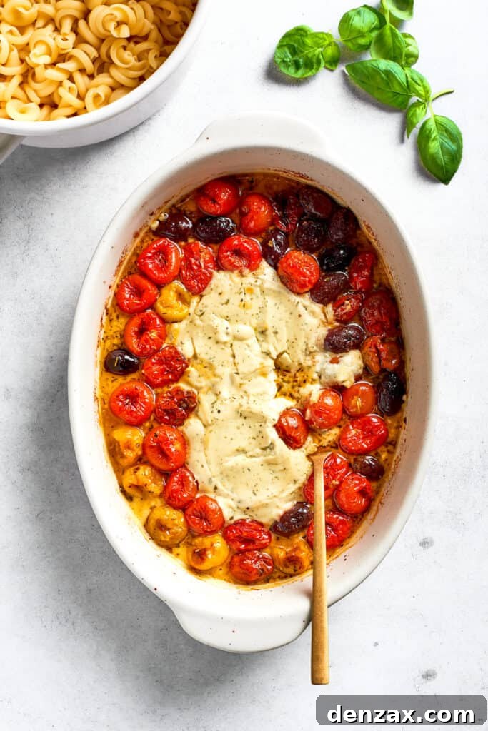 A spoon stirs the melted cheese into the tomatoes.