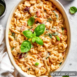 Baked pasta in a casserole dish garnished with fresh basil leaves.