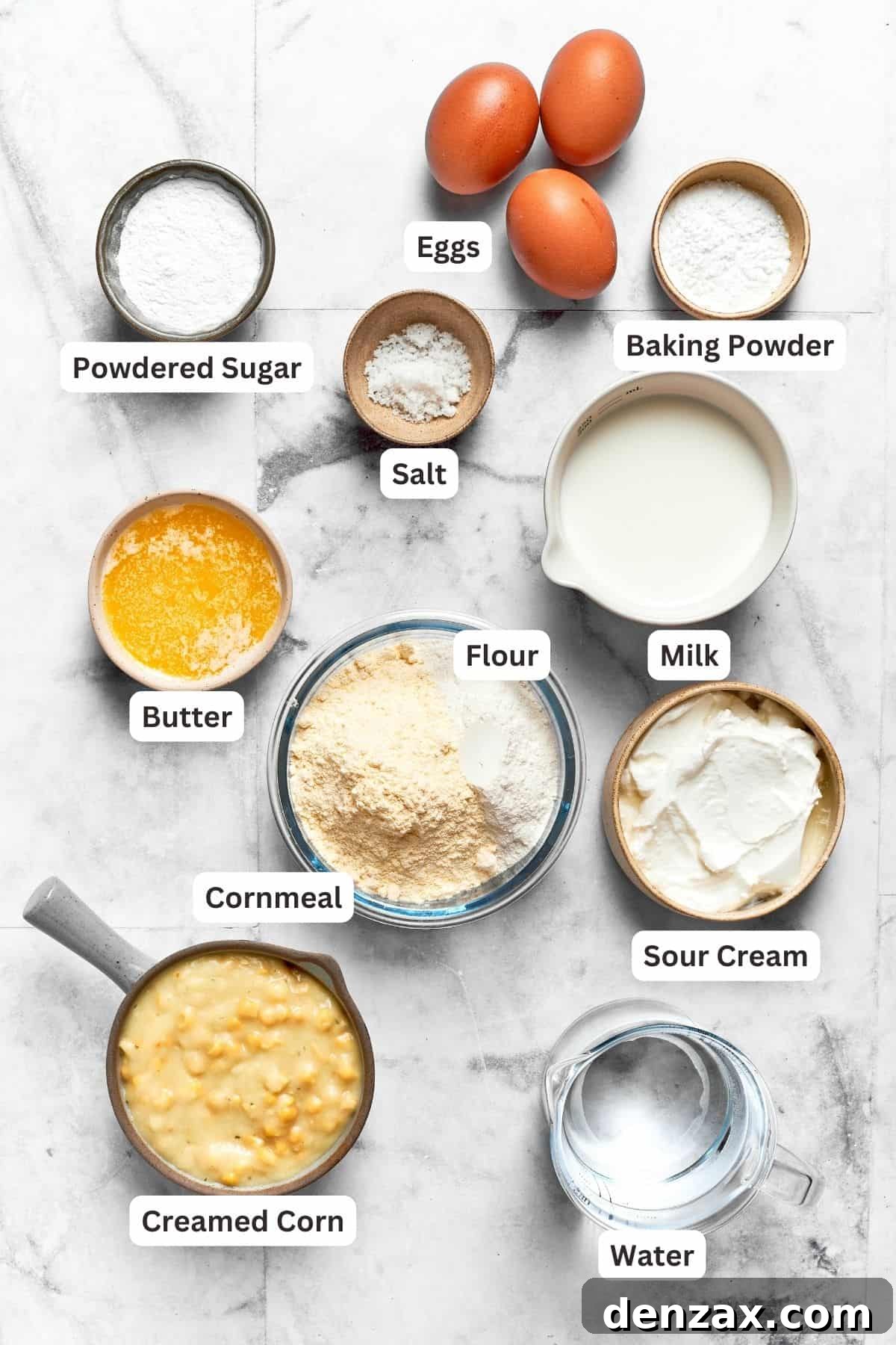 Ingredients needed for spoon bread are shown: baking powder, flour, cornmeal, butter, creamed corn, eggs, powdered sugar, water.
