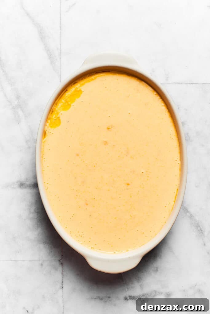 Spoon bread batter is shown in an oval baking dish.